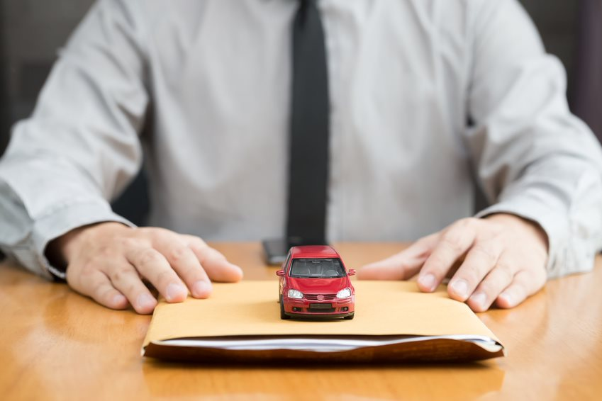 car dealer with paperwork and toy car
