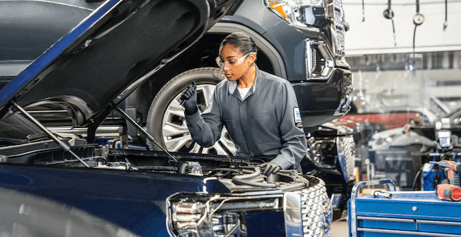 GMC technician inspecting an engine