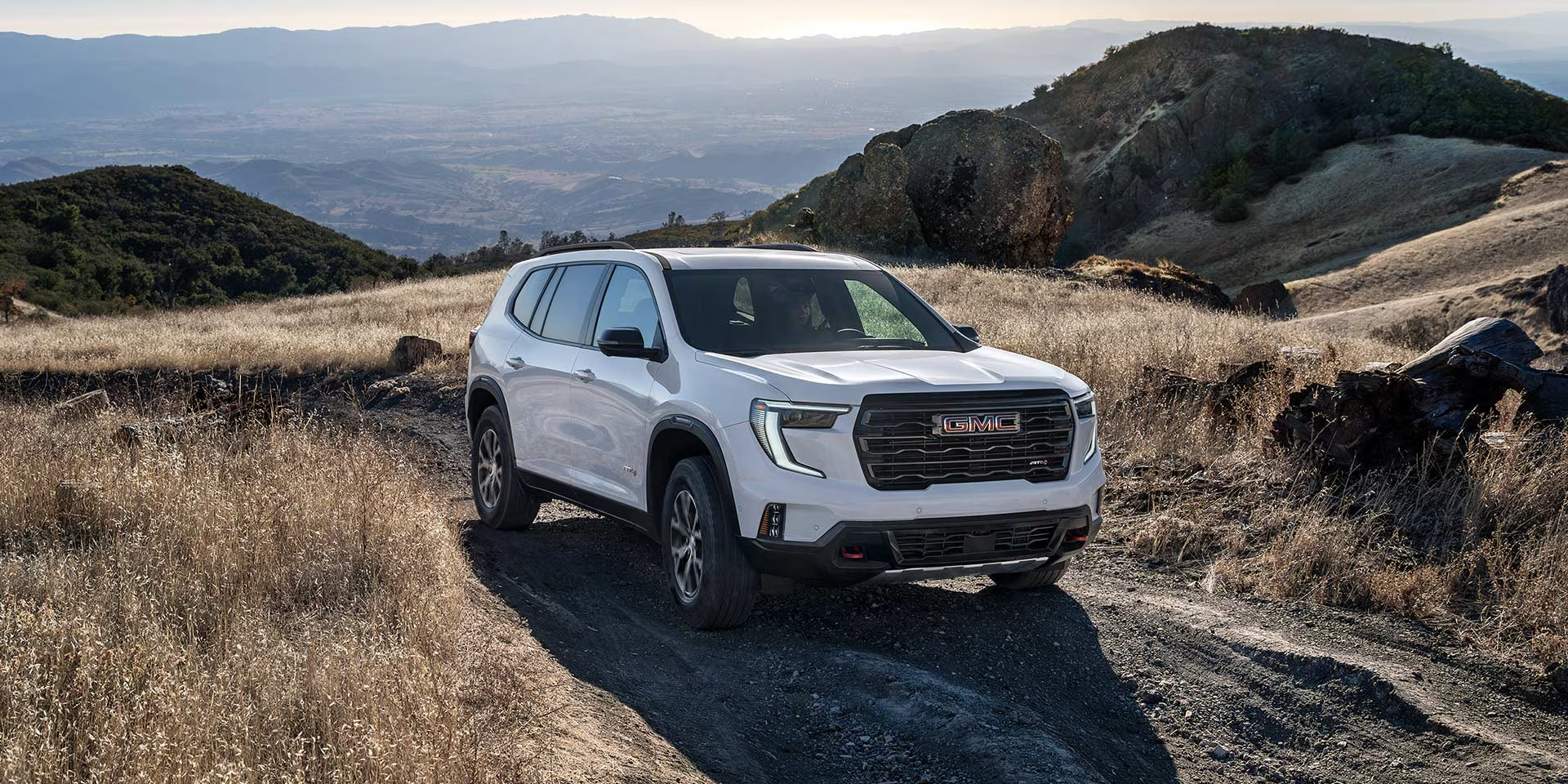 White 2027 GMC Acadia in mountainous terrain